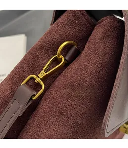 Close-up of premium gold hardware hook on a vintage dark brown suede handbag detail