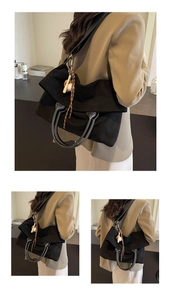 Détail du sac cabas en toile noire avec poignées en cuir et ornement tissé décoratif