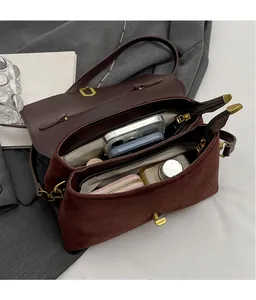 Internal view of brown leather crossbody bag showing dual compartments and high capacity