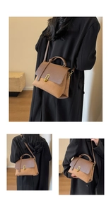 Detail view of two-tone crossbody bag with gold U-shaped lock and adjustable strap