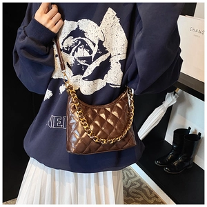 Detail of dark brown quilted hobo bag with gold chain and leather shoulder strap