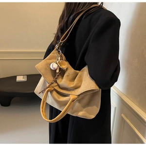 Vue détaillée du grand sac cabas en daim kaki avec pendentifs de baseball et lanières