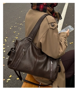 Gros plan détaillé d'un grand sac cabas marron en cuir texturé avec poches zippées