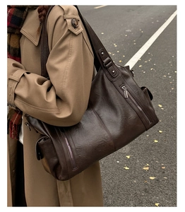 Détail du grand sac cabas marron foncé avec poche zippée porté avec un trench d'automne