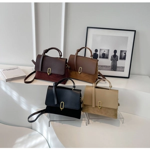 Minimalist vintage crossbody bags in four colors displayed on a white tiered stand