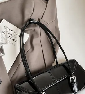Dettaglio borsa vintage in pelle cerata con manici lunghi e fibbia in metallo argento