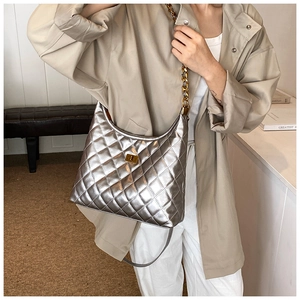 Detail of silver quilted hobo bag with gold chain strap and metallic texture
