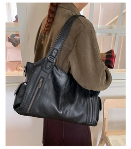 Détails du sac cabas noir avec large bandoulière, boucles en métal et poches