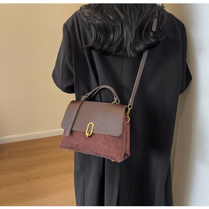 Detail of vintage retro crossbody bag in dark brown leather and burgundy suede stitching