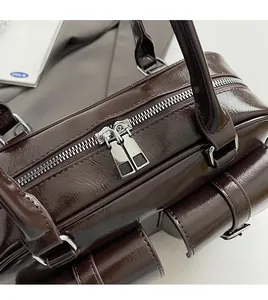 Close-up of smooth dual metal zippers and silver hardware on a vintage brown PU bag
