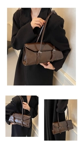 Dettaglio della borsa a spalla vintage in pelle cerata marrone scuro con fibbie argento