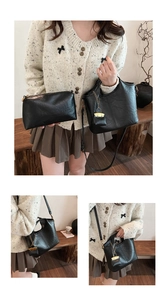 Detail of black vintage bucket bag set with gold pendant, leather texture and shoulder strap