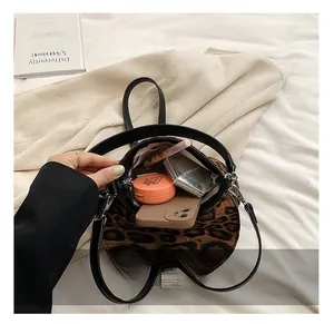 Interior view of leopard print shoulder bag showing phone and makeup storage space