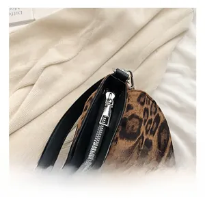 Detail view of leopard print saddle bag with premium silver zipper and black leather trim