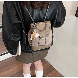 Detail of frosted two-tone chain backpack with baseball pendant shown on shoulder