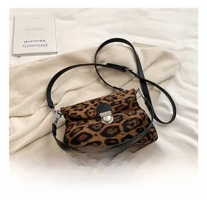 Detail shot of the leopard print crossbody bag featuring a silver round metal lock