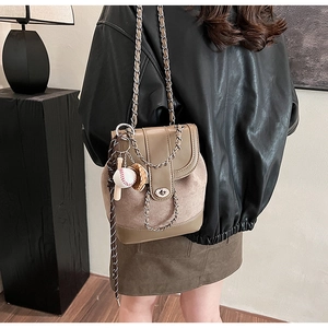 Fashionable khaki frosted chain backpack with vintage baseball charm on a female model