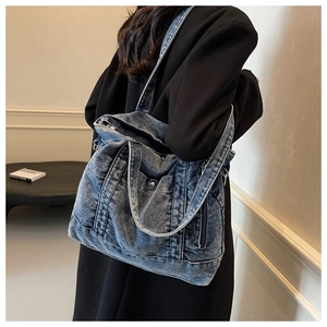 Close-up of the vintage washed denim tote bag with functional pockets and straps