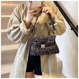 Close-up of leopard print handbag with metallic twist-lock and black leather strap