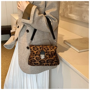 Close-up of leopard print shoulder bag with silver metal buckle and leather strap