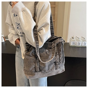 Close-up of washed grey denim tote bag showing vintage texture and functional zippers