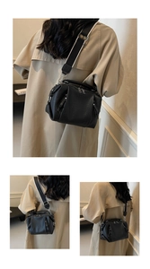 Detail of black lychee grain leather Boston bag with bicolor wide canvas strap