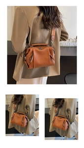 Detailed view of caramel leather boston bag featuring lychee texture and side tassel accents