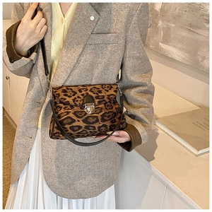 Detail of leopard print crossbody bag with vintage metal buckle and slim black shoulder strap