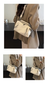 Detail of cream lychee leather texture on a Boston bag with adjustable wide strap