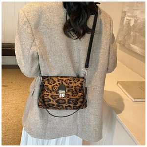 Detail of leopard print crossbody bag with black leather strap and silver metal buckle