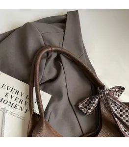 Detail of brown litchi leather tote bag with checkerboard silk scarf and sturdy handle