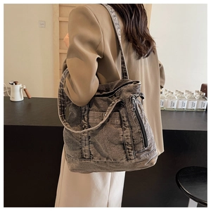 Detail of vintage gray denim tote bag featuring side metal zipper and contrast stitching