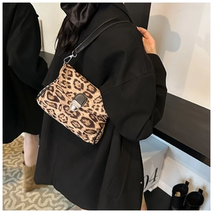Close-up of stylish leopard print crossbody bag on model with black blazer outfit
