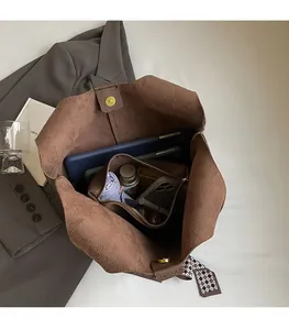 Spacious interior of brown pebbled leather bucket bag with magnetic closure and zip pocket