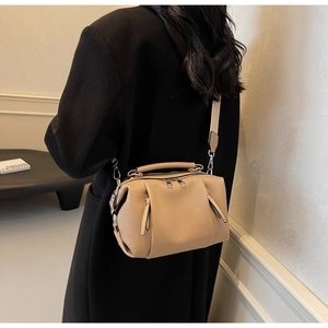 Detail of camel leather pillow bag with wide shoulder strap and silver hardware accents