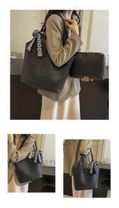 Detail of large black bucket bag with lychee texture and a checkerboard silk scarf bow