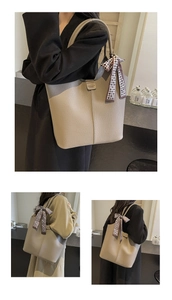Detail view of khaki pebbled leather tote bag with stylish checkered scarf decoration