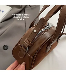 Detail van de verstelbare zilveren schouderbandgesp op een bruine crossbody tas