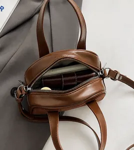 Binnenaanzicht van kleine bruine kunstlederen crossbodytas met ruimte voor telefoon en portemonnee