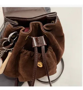Détail du sac seau en daim avec fermeture à cordon et boucle magnétique métallique