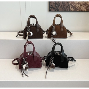 Detail van de zadelvormige crossbodytassen met honkbalhangers en mat afgewerkt leer