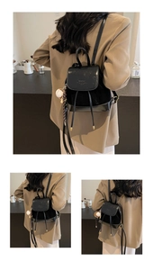 Détail d'un mini sac à dos noir chic orné d'un accessoire pendentif de baseball élégant