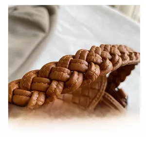 Close-up of brown woven leather texture and intricate braided handle detail