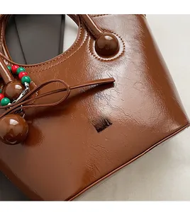Vue macro de la texture en cuir marron brillant et du logo embossé sur le sac