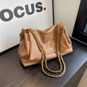 Chic brown leather shoulder bag with gold chain strap on a wooden surface