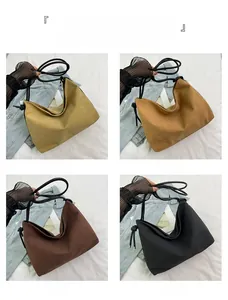 Détail de grands sacs fourre-tout en toile à poignées nouées en quatre tons terreux