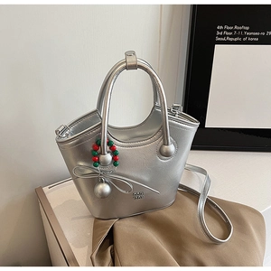 Détail du sac à main en cuir argenté métallisé avec charms perlés et logo embossé