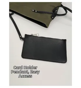 Detail of army green canvas tote with a black leather card pouch attachment