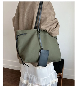 Detail view of army green canvas tote with black leather straps and detachable coin purse