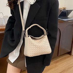 Minimalist beige woven leather crossbody bag with rounded handle and detachable strap